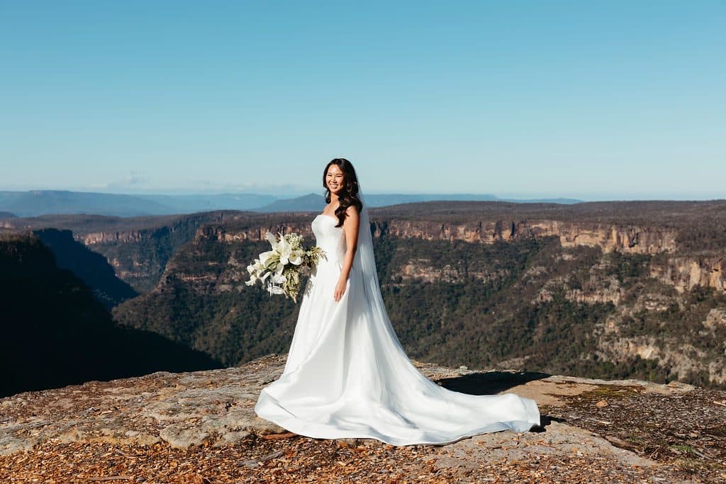 Ann alone on the sandstone at the edge of The Cliffs, her train spread out and the gorge behind
