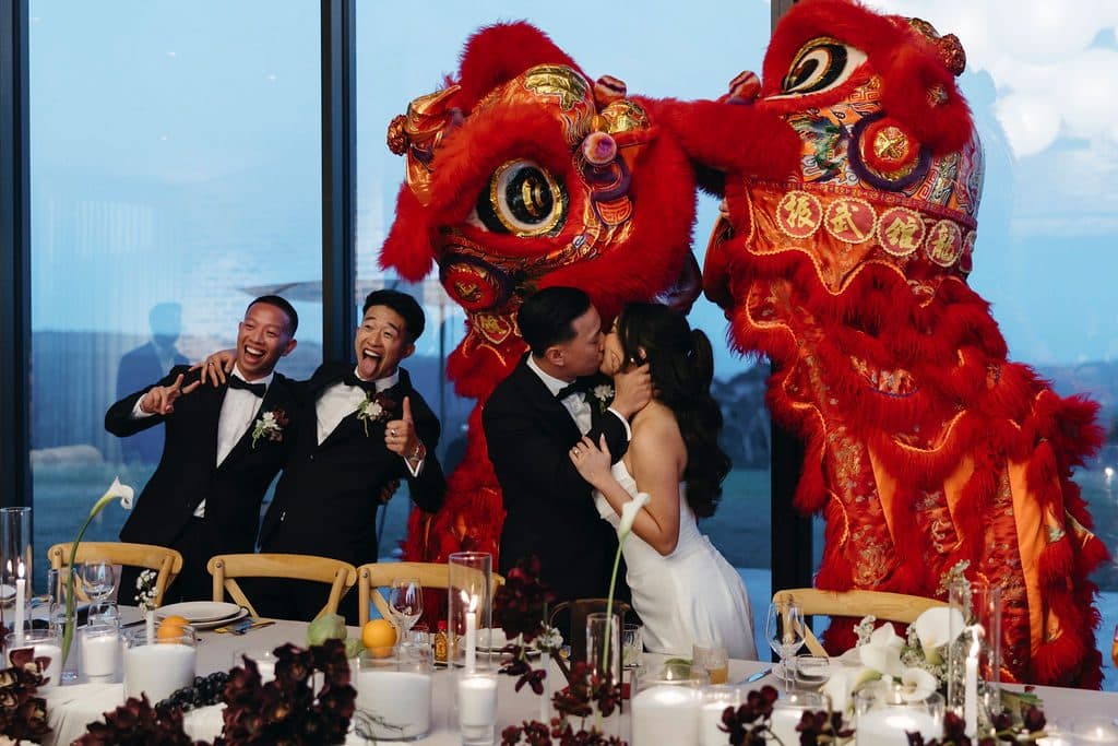 The lion dance at the bridal table in The Pavilion, Ann and Winston kissing between the two lions