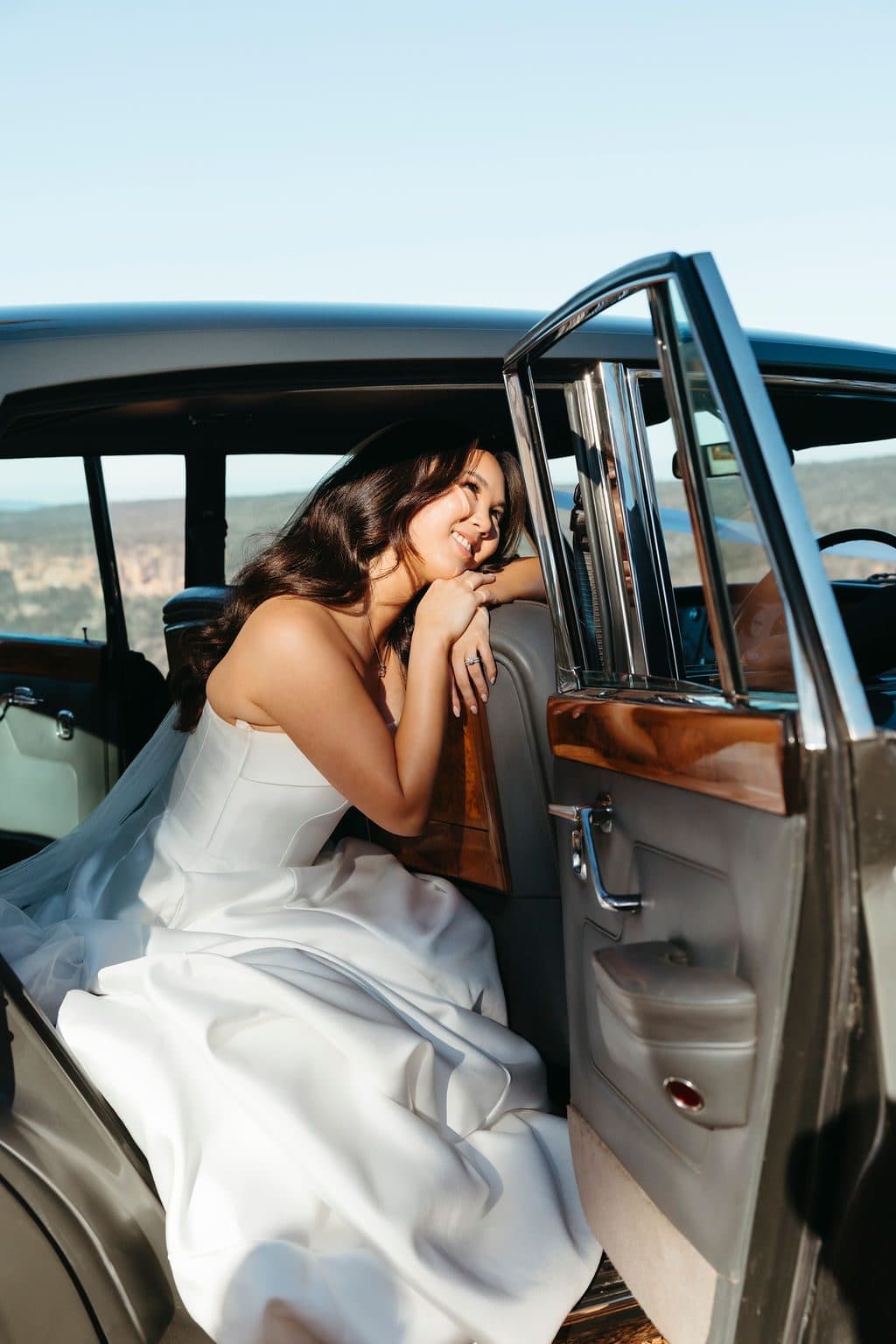 Ann laughing in the back seat of the Rolls-Royce, the door open on the gorge