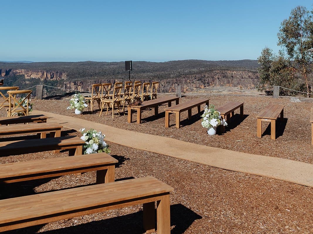 Guests seated on timber benches at the clifftop ceremony site