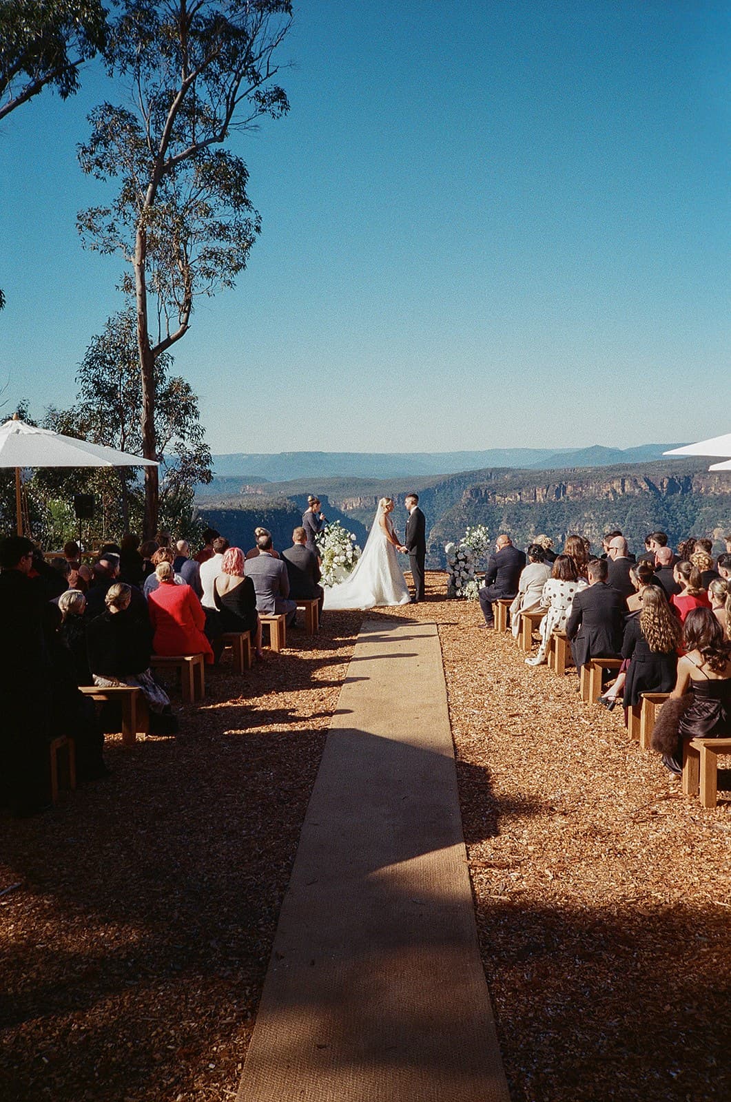 The aisle at The Cliffs looking out over the gorge, guests seated on timber benches either side