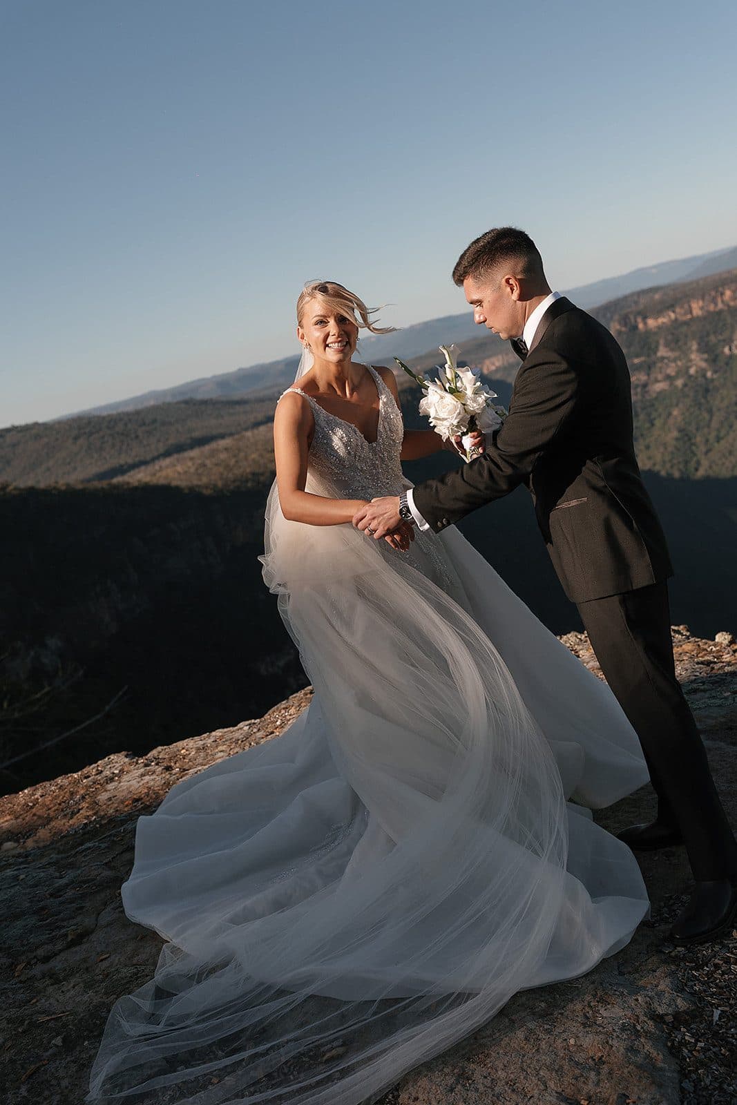 Lauren and Corey at the edge of The Cliffs, her gown spread across the sandstone