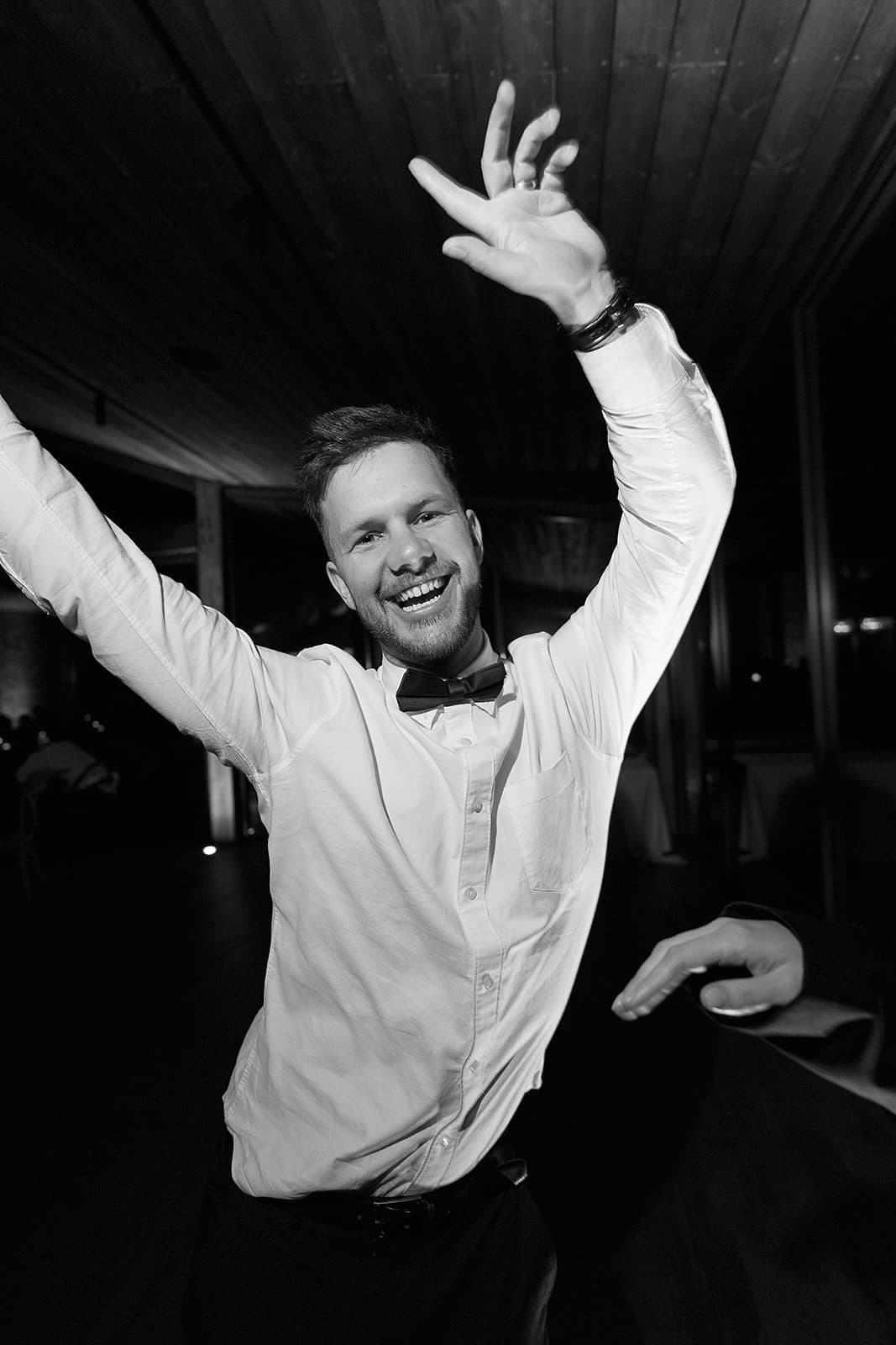 Corey on the dance floor, arms in the air