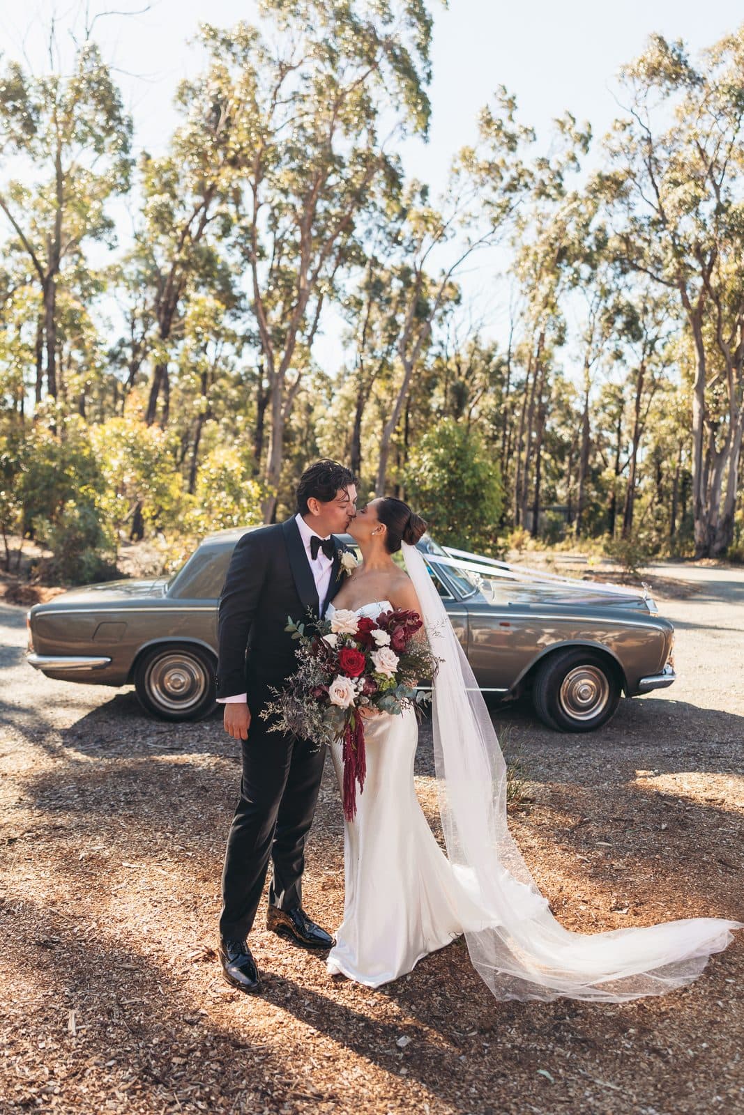 Liv and Ryan kissing beside the Rolls-Royce among the gums at The Cliffs