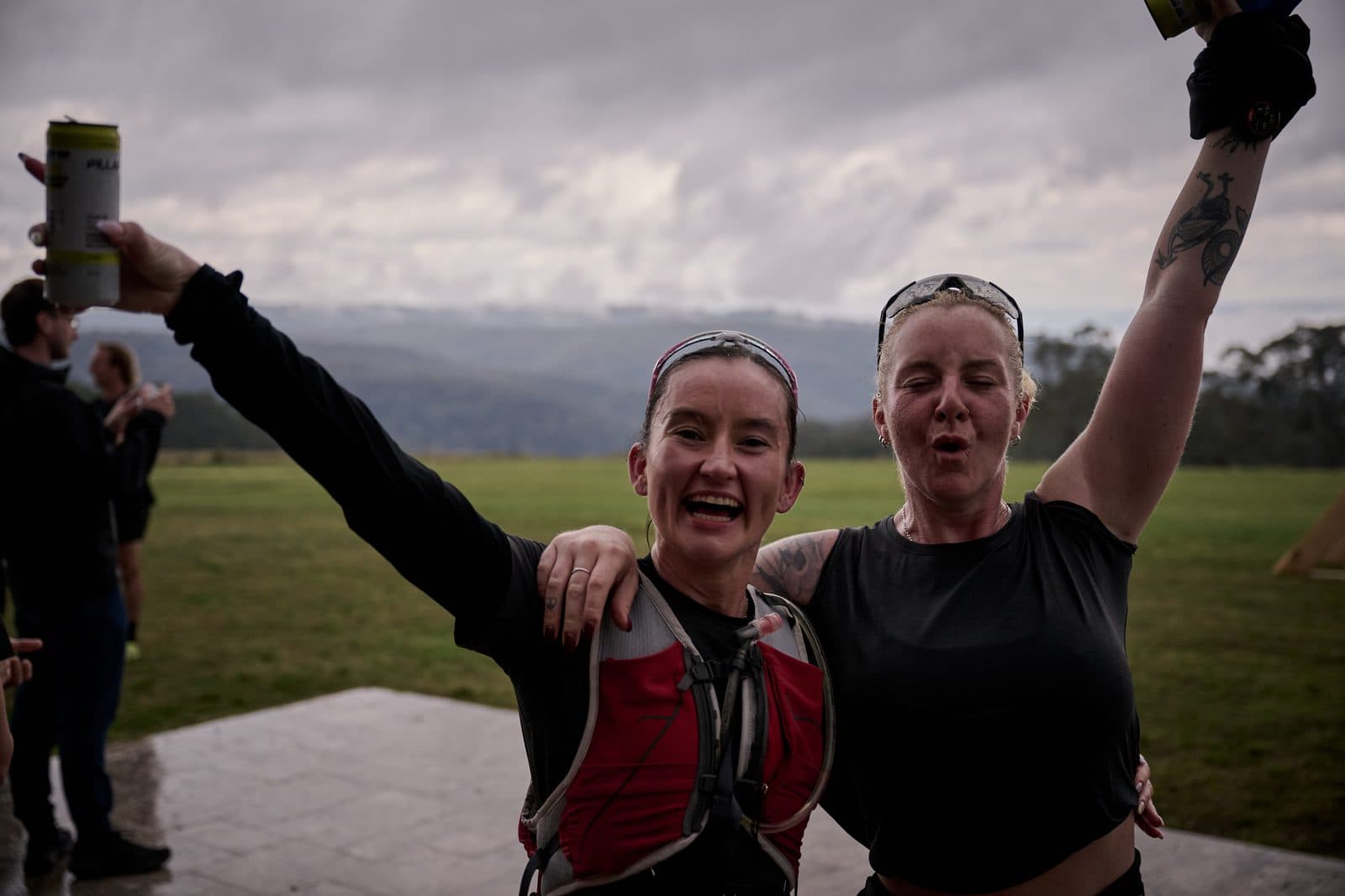 Two finishers celebrating with arms raised on the terrace