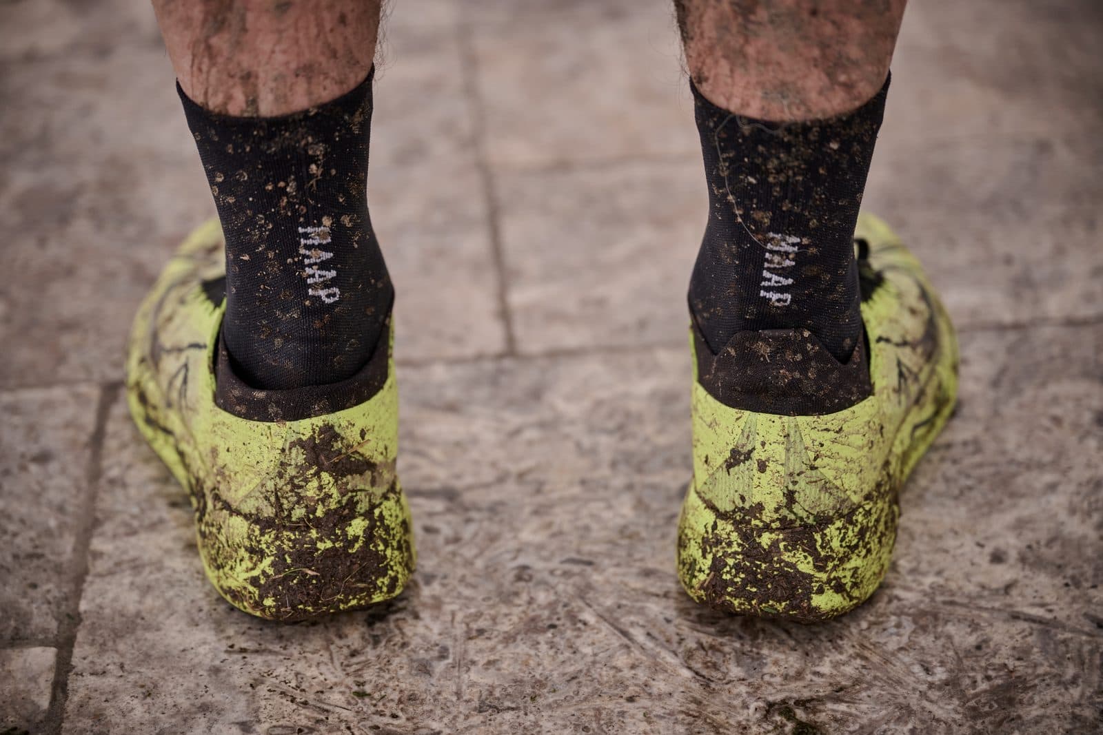 Mud-caked shoes and socks on the terrace paving after the run