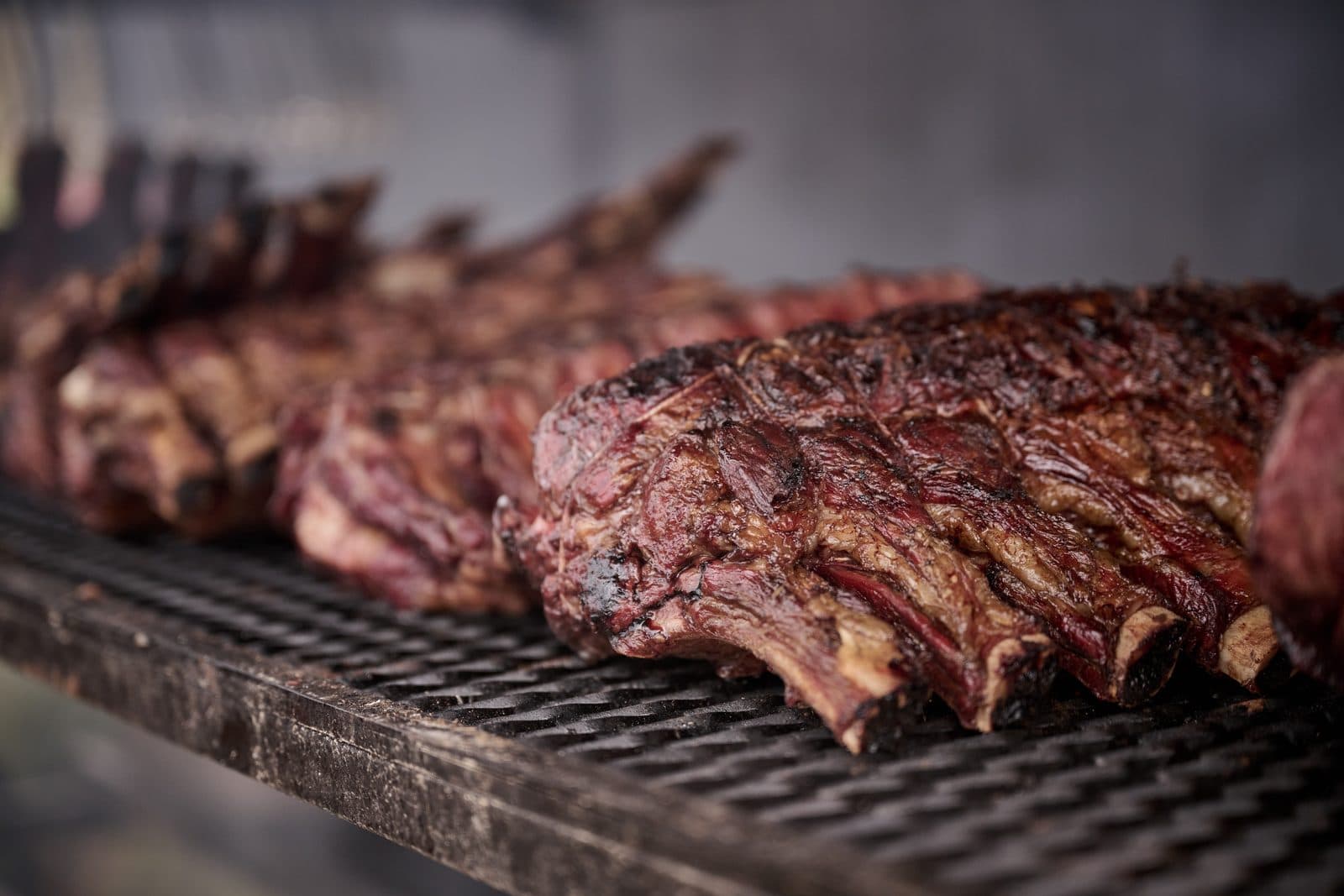 Racks of ribs charring on a grill over the fire