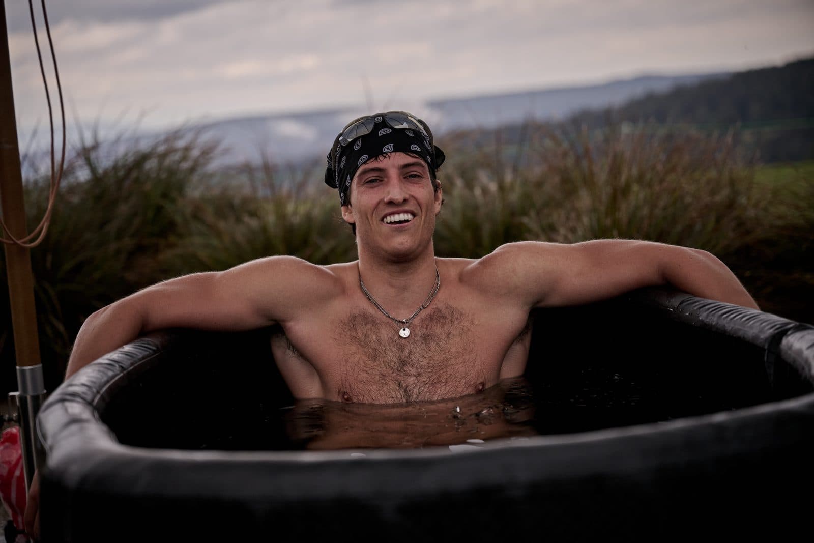 A runner leaning back in an ice bath on the terrace