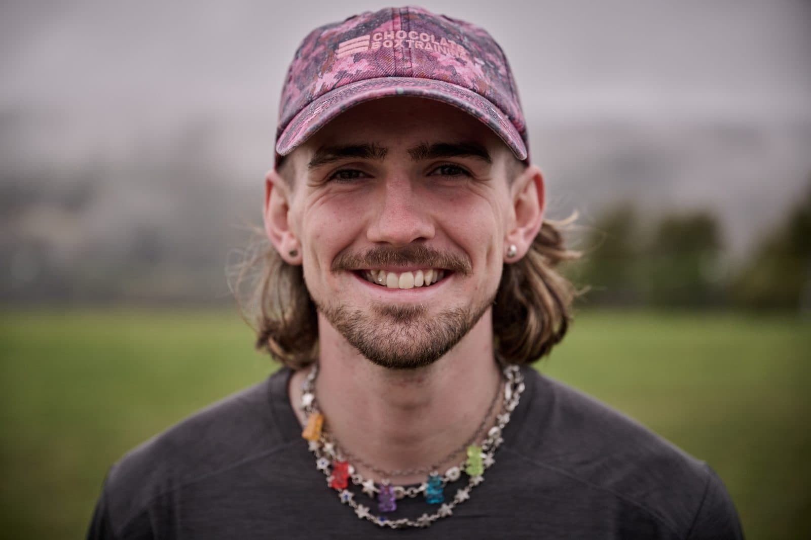 A runner in a faded cap and a beaded necklace, laughing