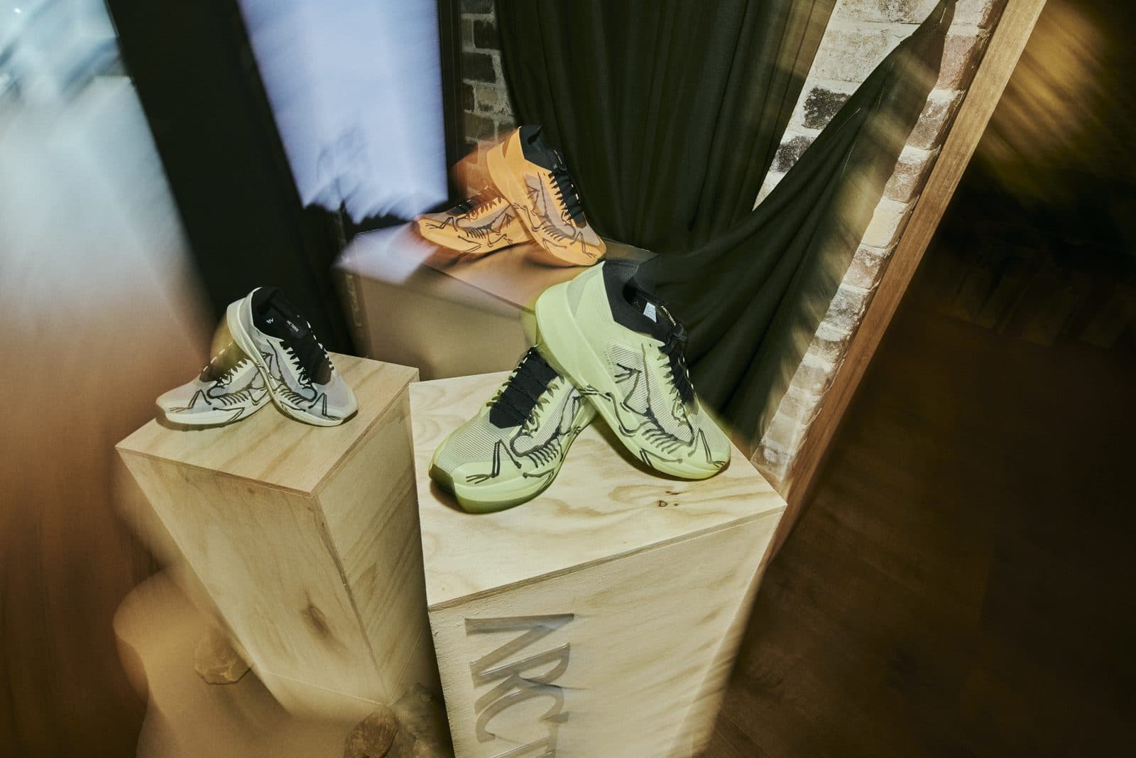 Sylan 2 shoes displayed on timber plinths branded with the Arc'teryx bird