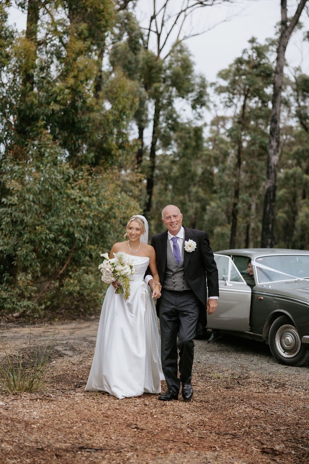Anna walking in on her father's arm among the gums, the Rolls-Royce behind them