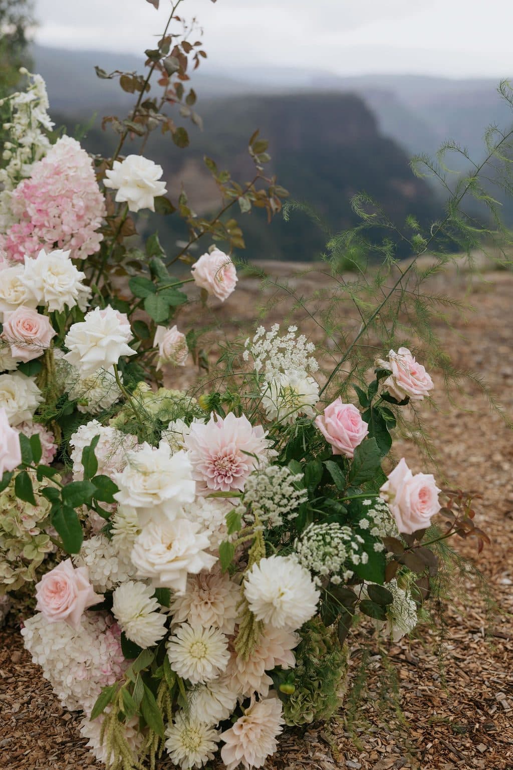 The ceremony florals left at the edge of The Cliffs, cloud over the gorge behind
