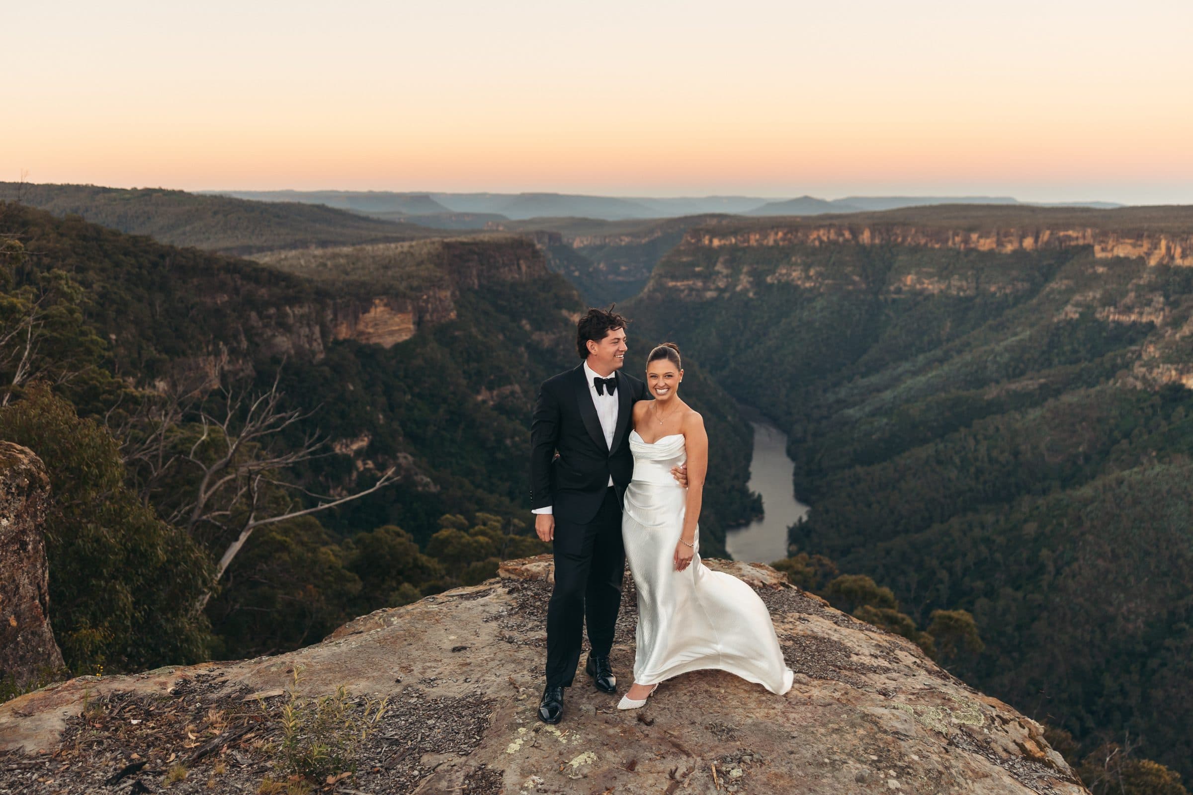 A couple on the clifftop above the Shoalhaven gorge at golden hour