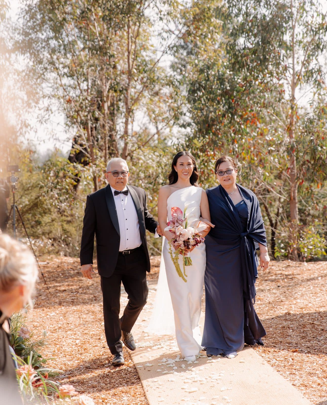 Jamae walking down the aisle between her father and mother