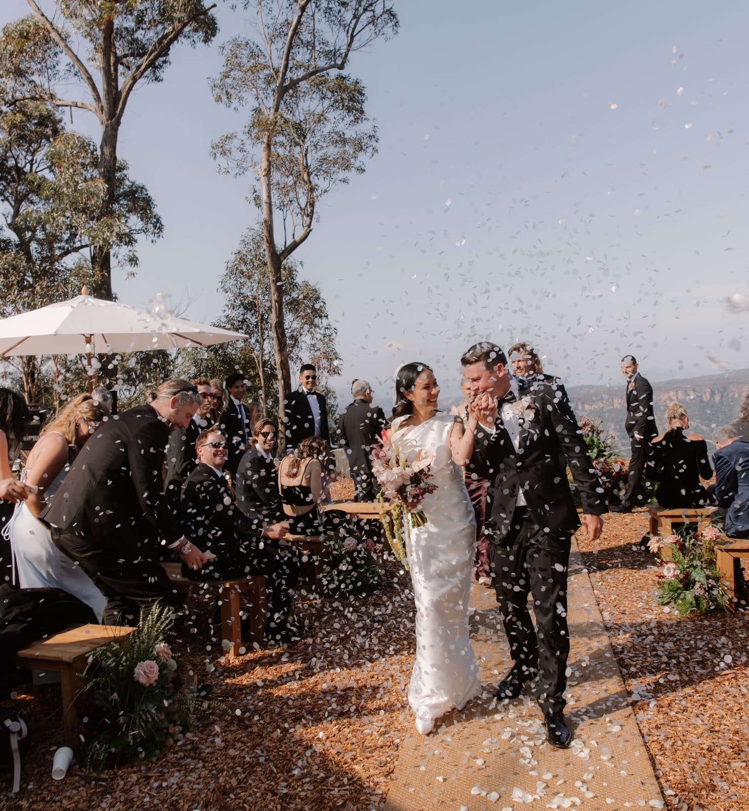 Jamae and Ben coming back up the aisle through a shower of confetti