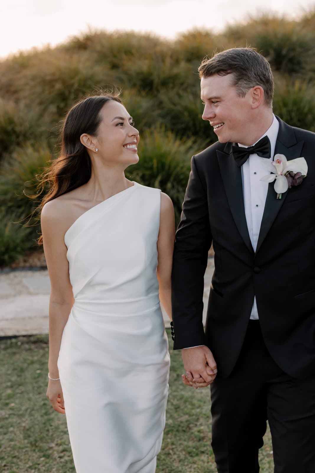 Jamae and Ben walking hand in hand in the golden light, smiling at each other