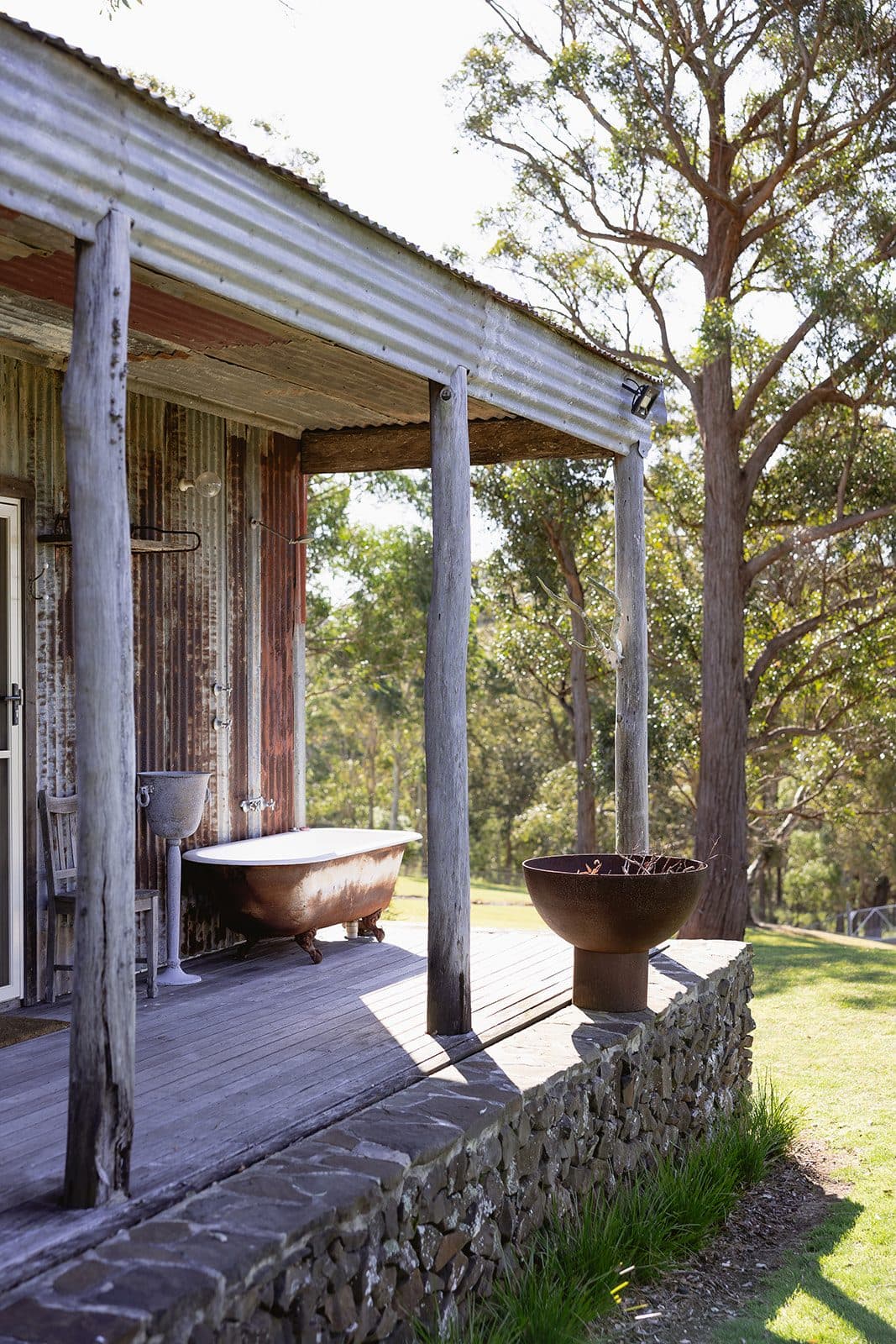 The Homestead verandah with its freestanding bath, looking out to the paddock and gums