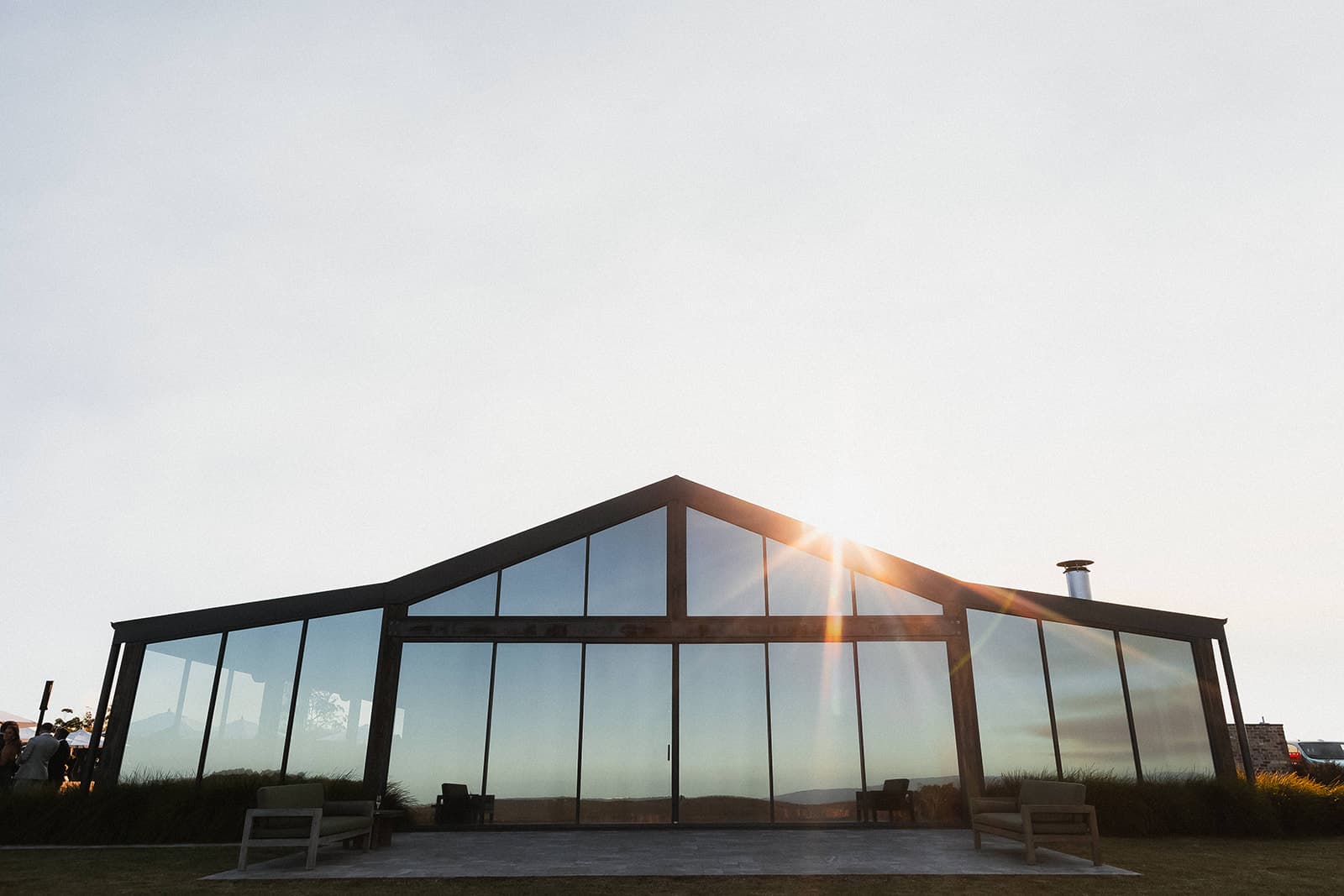 The Pavilion's floor-to-ceiling glass walls glowing at sunset