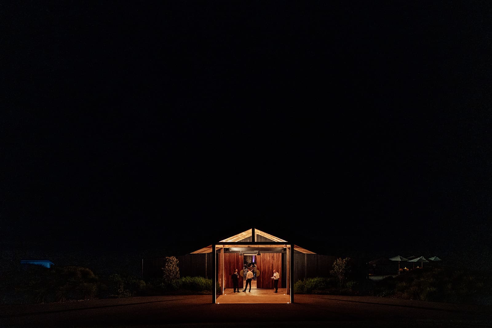 The couple against the Pavilion's floor-to-ceiling glass at sunset